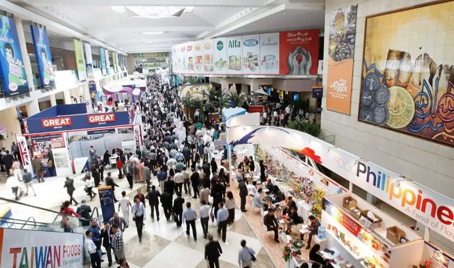 Crowds walking past international food pavilions in an exhibition hall at the Gulfood exhibition
